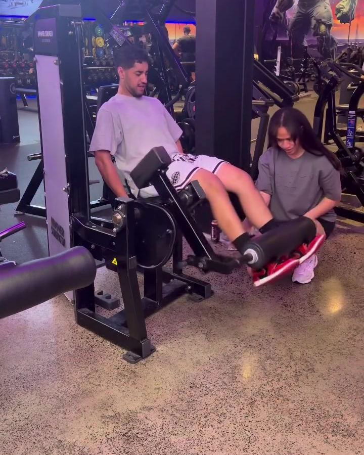 Rachel coaching a client through a leg extension at Fitness Cartel