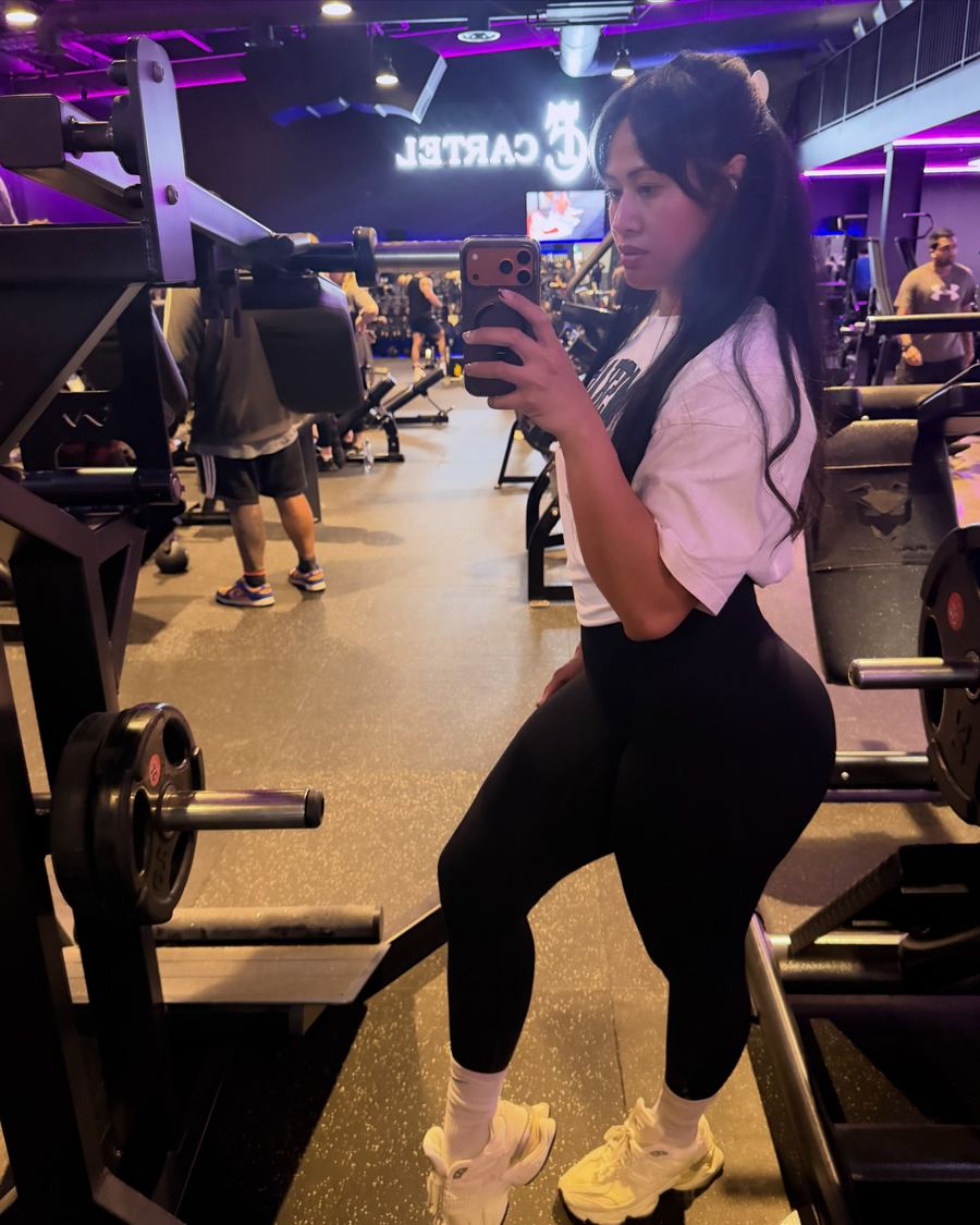 Rachel on the gym floor at Fitness Cartel under purple lights
